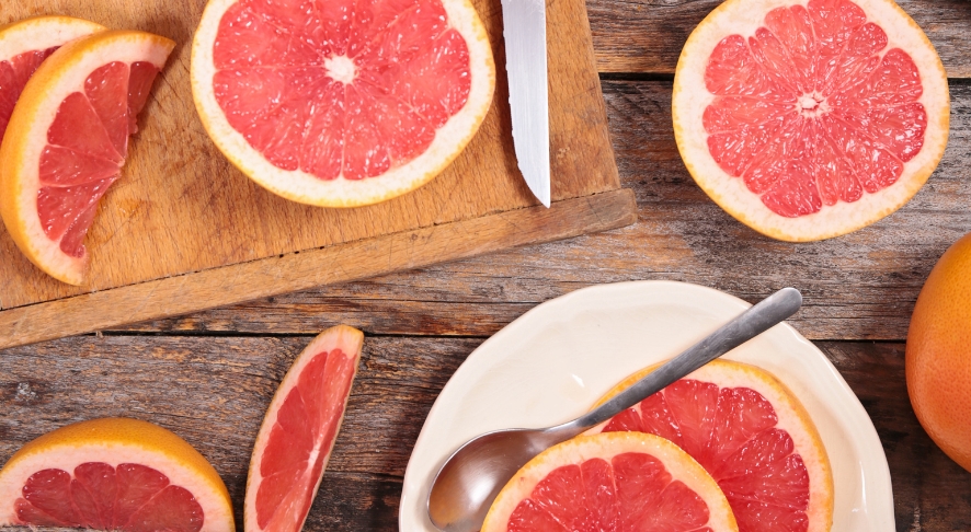 Slices of red grapefruit on cutting board.