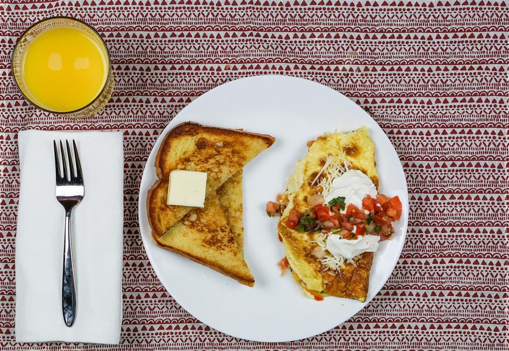 French toast with salsa omelet and orange juice on table